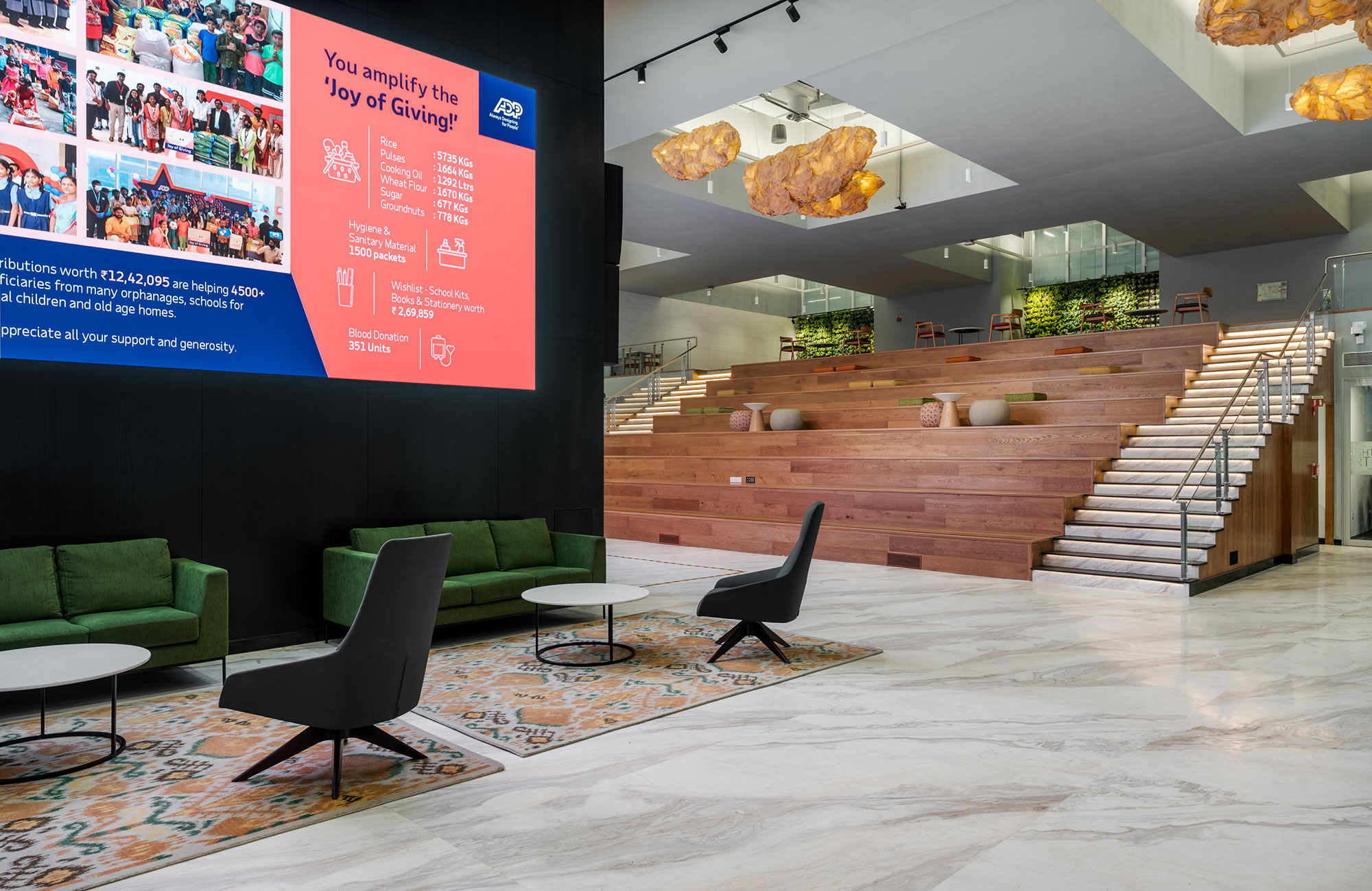 A room with green couches and a large screen.